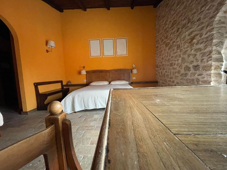 Spazio quieto in un agriturismo, con pareti dai toni caldi e arredamento in legno semplice.
