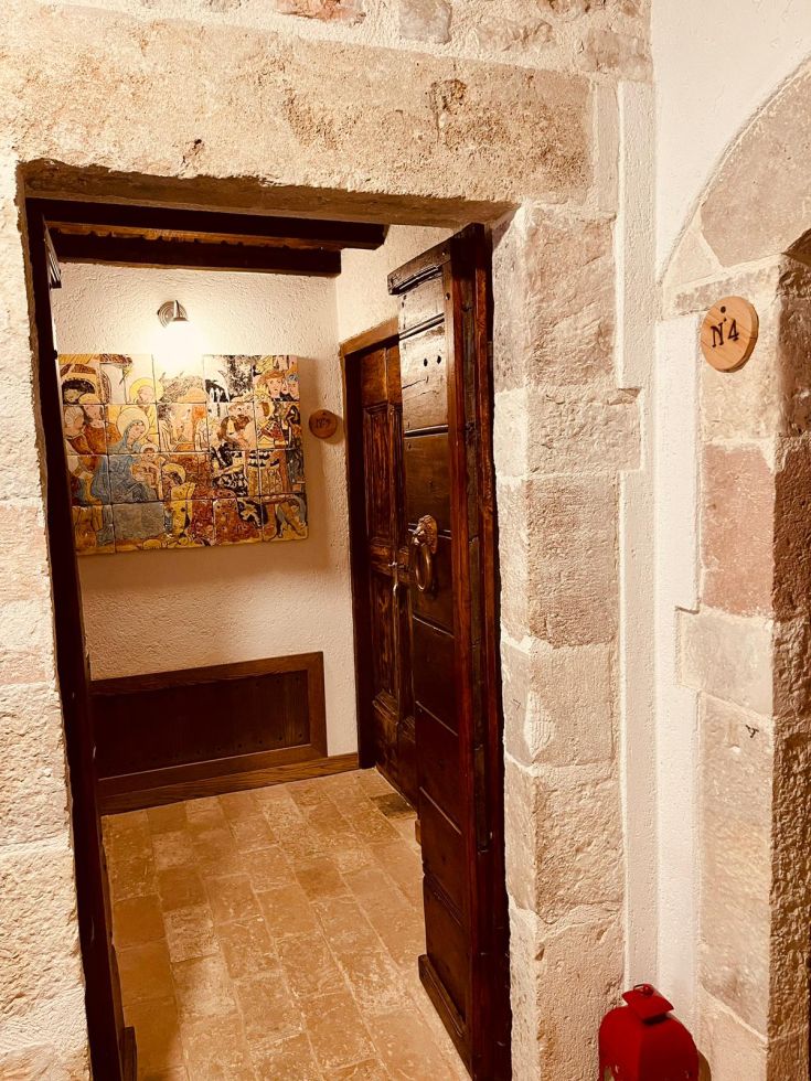 Un corridoio semplice con porte in legno e decorazioni, che trasmette una sensazione di familiarità.