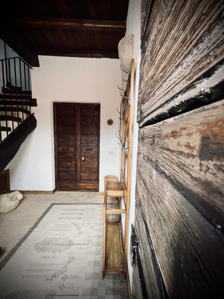 Un ingresso semplice con elementi in legno e un tappeto colorato.