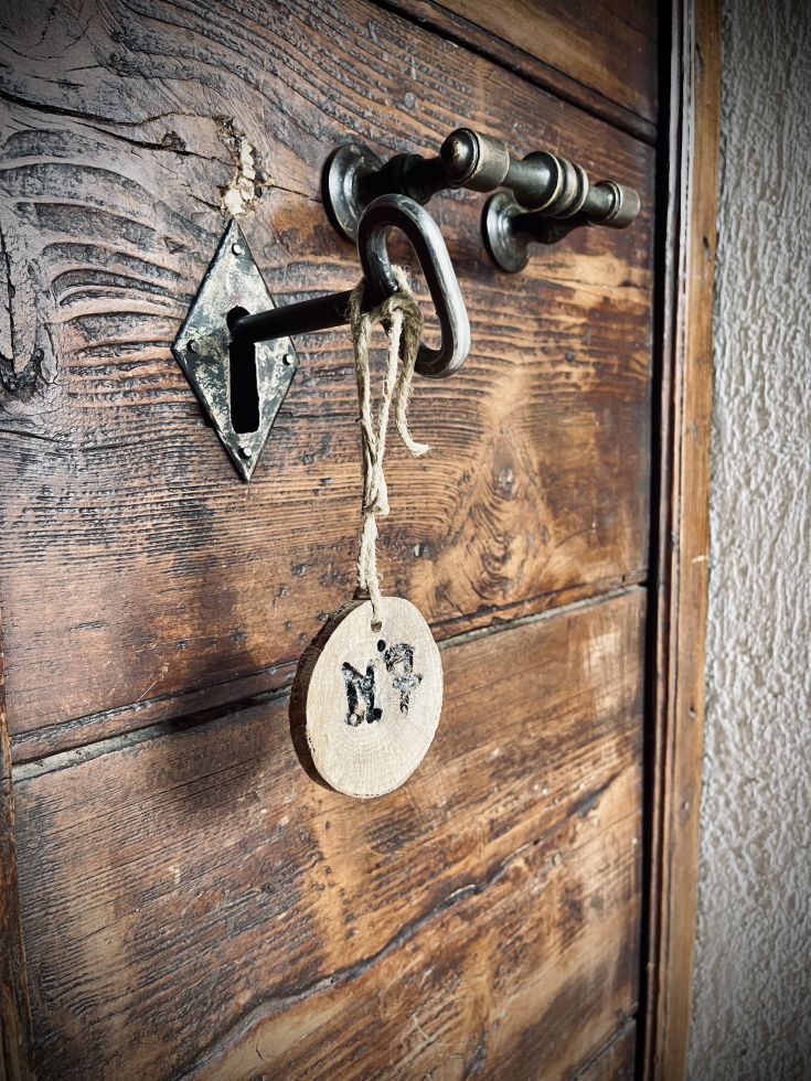Immagine di una chiave e di un'etichetta su una porta di legno semplice.