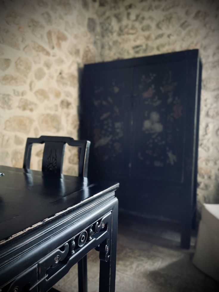 Ambiente rustico caratterizzato da un tavolo in legno e un armadio di tonalità scura.