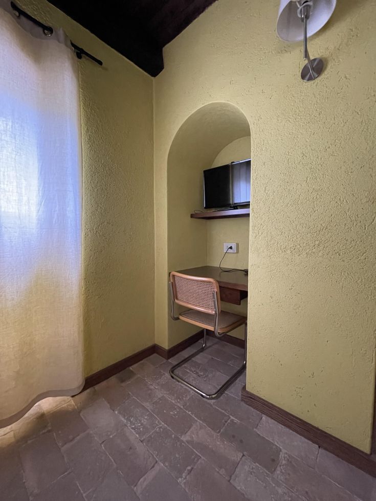 Un'area semplice con una scrivania e una TV, che trasmette un'atmosfera tranquilla e confortevole.