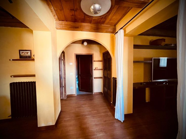 Interno di un appartamento confortevole con finiture in legno e pareti di colore giallo.