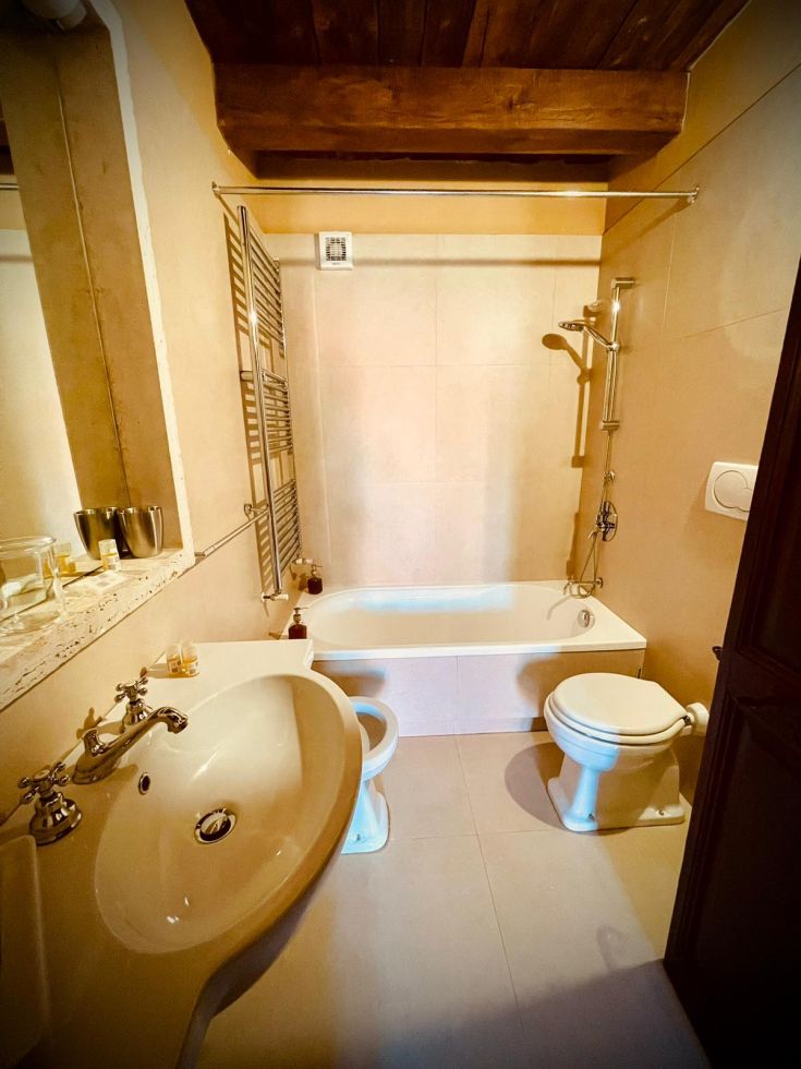 Interno di un bagno semplice, con una vasca e sanitari dal design lineare.