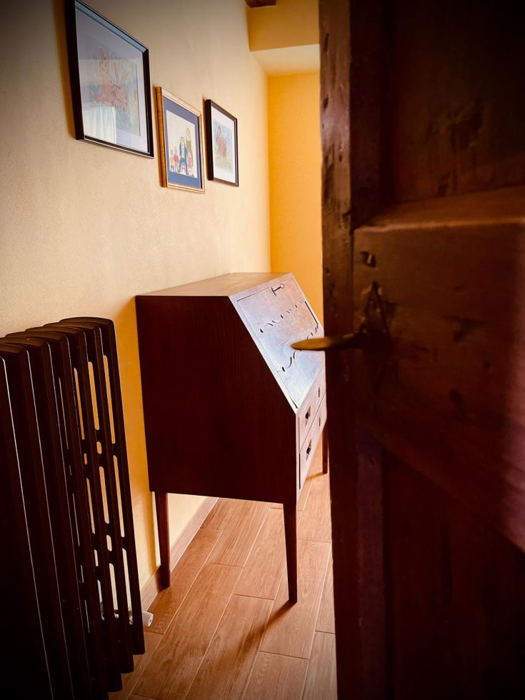 Un interno semplice e accogliente con mobili in legno e decorazioni appese alle pareti.