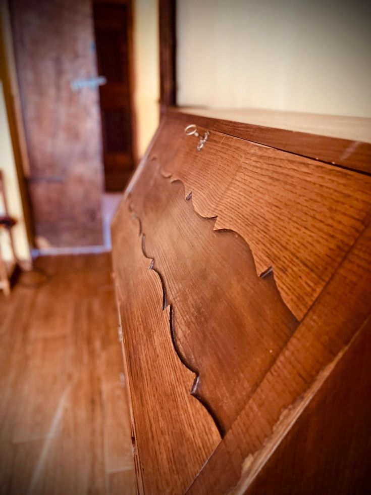 Particolare di un mobile in legno con un design semplice, collocato in un ambiente intimo.