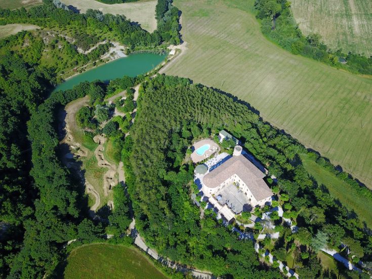Ancient 12th-century structure in Umbria, surrounded by greenery and rich in history.