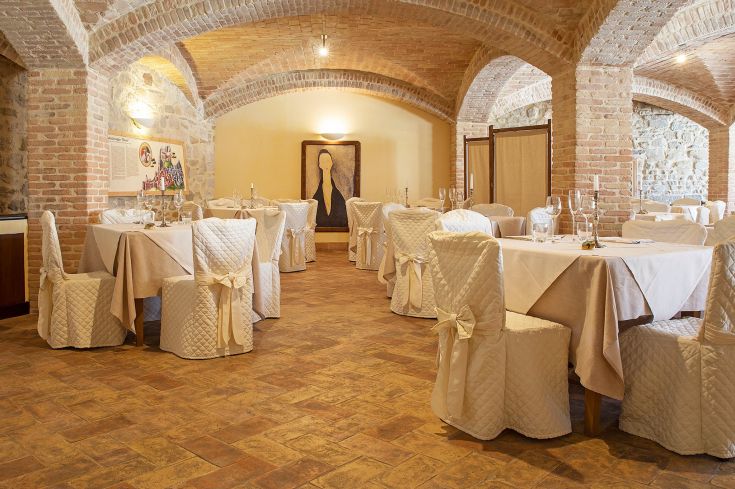 A refined restaurant with carefully set tables, historic architecture, and a pleasant atmosphere.