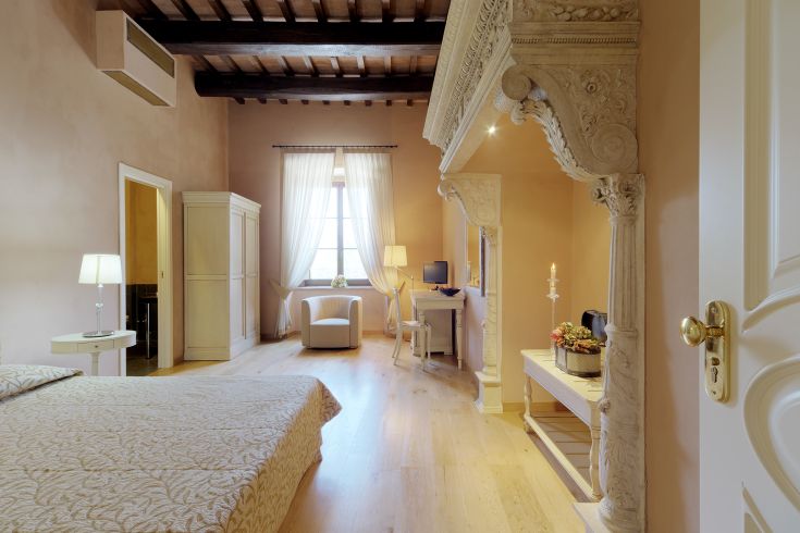 Interior of a palace featuring spacious rooms illuminated by large windows, with modest furnishings.