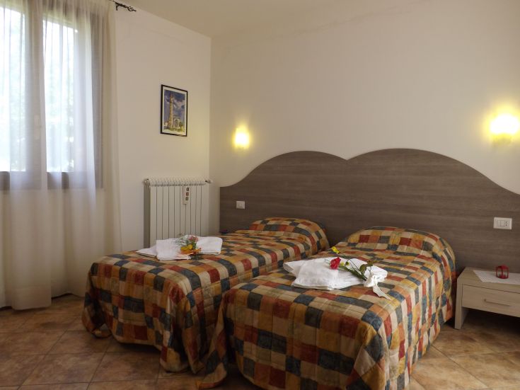 Bequeme Doppelzimmer mit Einzelbetten, dekoriert mit Blumen und Blick auf die umliegende Natur.