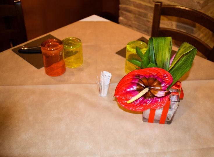 Ein dekorierter Tisch mit einem lebhaften Blumenschmuck und glänzendem Glasgeschirr.