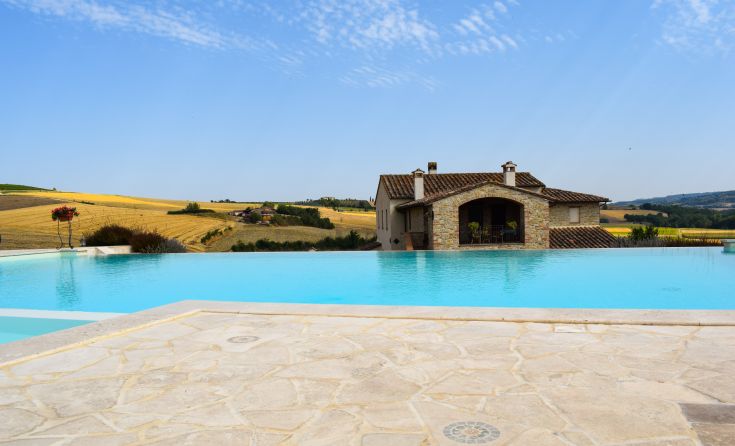 Szene eines Infinity-Pools mit Hügeln im Hintergrund; einfache und naturnahe Umgebung.