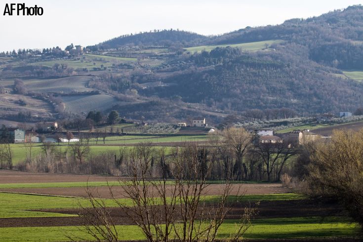 Szene von grünen Hügeln, die mit Häusern und Bäumen gesprenkelt sind, verkörpern Ruhe und natürliche Schönheit.