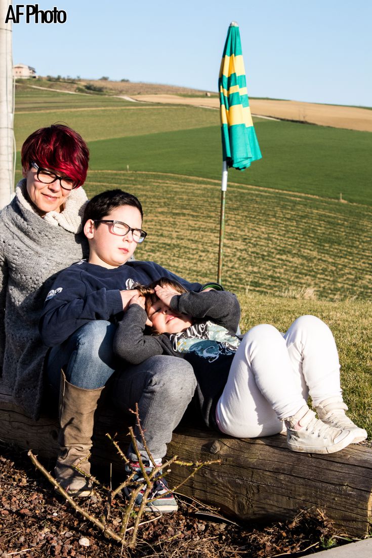 Eine Familie verbringt einen Tag im Freien zwischen den Feldern, umgeben von Grün.