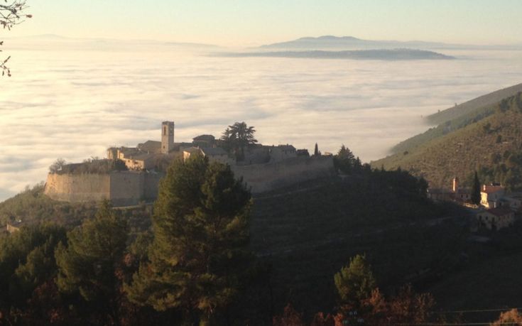 Ein Gebäude umgeben von Natur, mit Wolken und ruhigen Landschaften im Hintergrund.