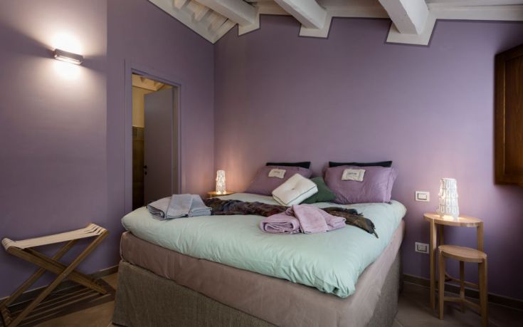 Elegantes Zimmer mit lila Wänden und bequemen Betten. Warme Atmosphäre mit modernen Elementen.