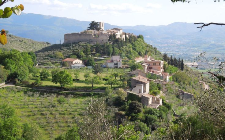 Ein Panorama des mittelalterlichen Dorfes Campello Alto, umgeben von Grün mit sichtbaren alten Strukturen.