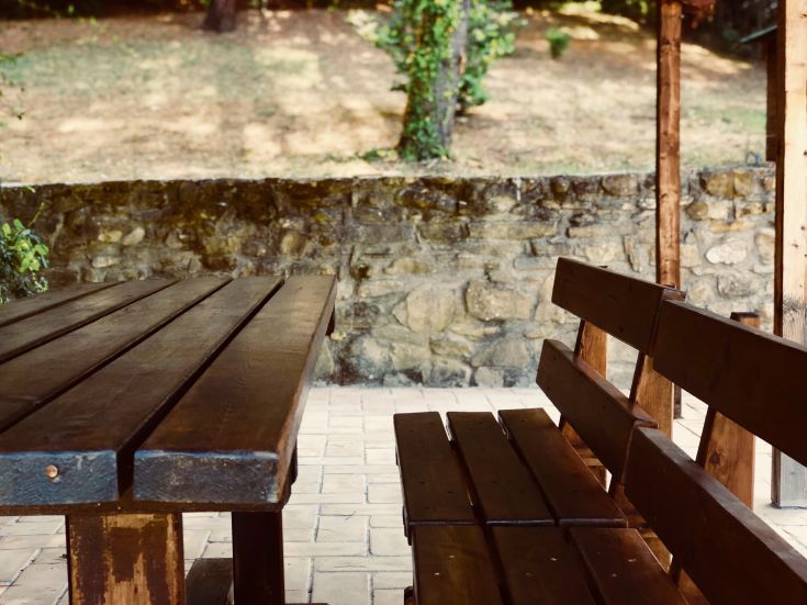 Un'area serena di un agriturismo in legno, circondato da vegetazione e natura.