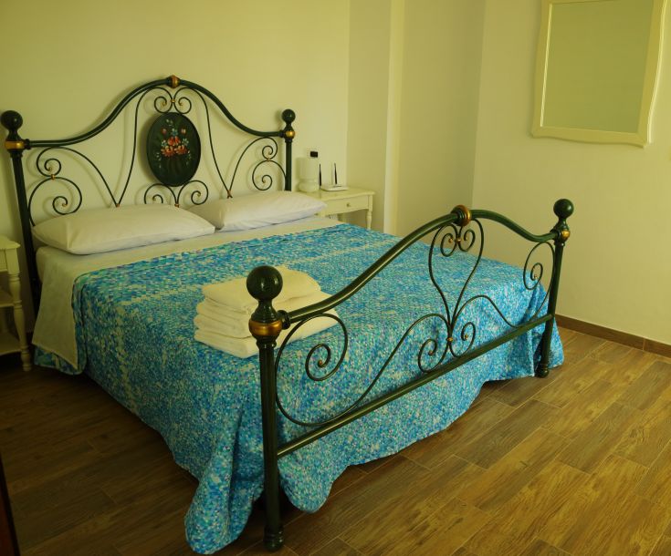 Camera semplice e confortevole con letto matrimoniale e biancheria, adatta per un soggiorno tranquillo.