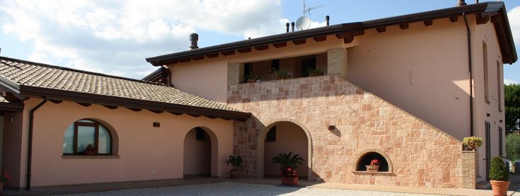Edificio in stile umbro immerso nella vegetazione locale, luogo tranquillo per momenti di relax.