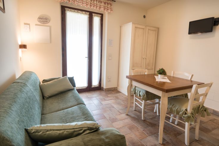 Accogliente appartamento con soggiorno, tavolo da pranzo e un ingresso ben illuminato.