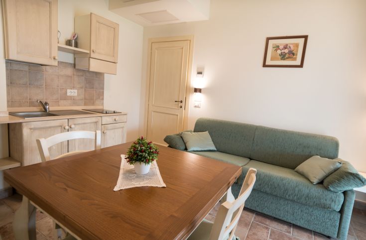 Interni ben illuminati con cucina e area soggiorno, ideali per un soggiorno confortevole.