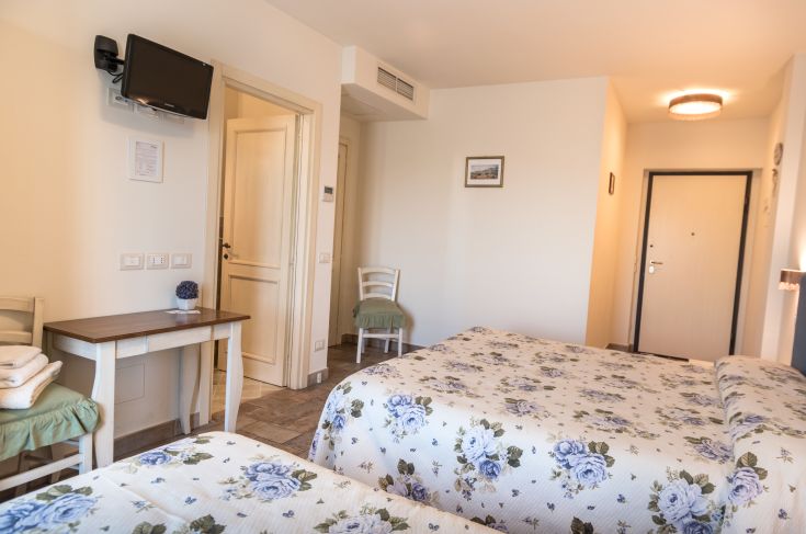 Camera luminosa e confortevole, arredata con letti decorati e dotata di TV. Spazio adatto per il relax in Umbria.