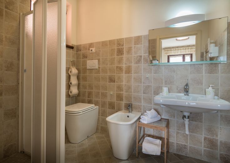 Un bagno semplice e luminoso, dotato di doccia, lavabo e wc in un'atmosfera confortevole.