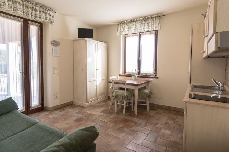 Spazioso appartamento con cucina attrezzata, tavolo e un soggiorno confortevole. Perfetto per momenti di relax.