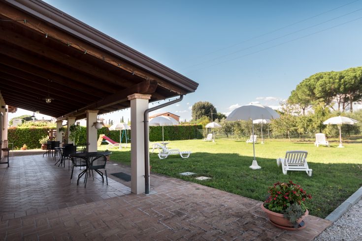 Giardino spazioso con ombrelloni e lettini, perfetto per momenti di relax all'aperto.