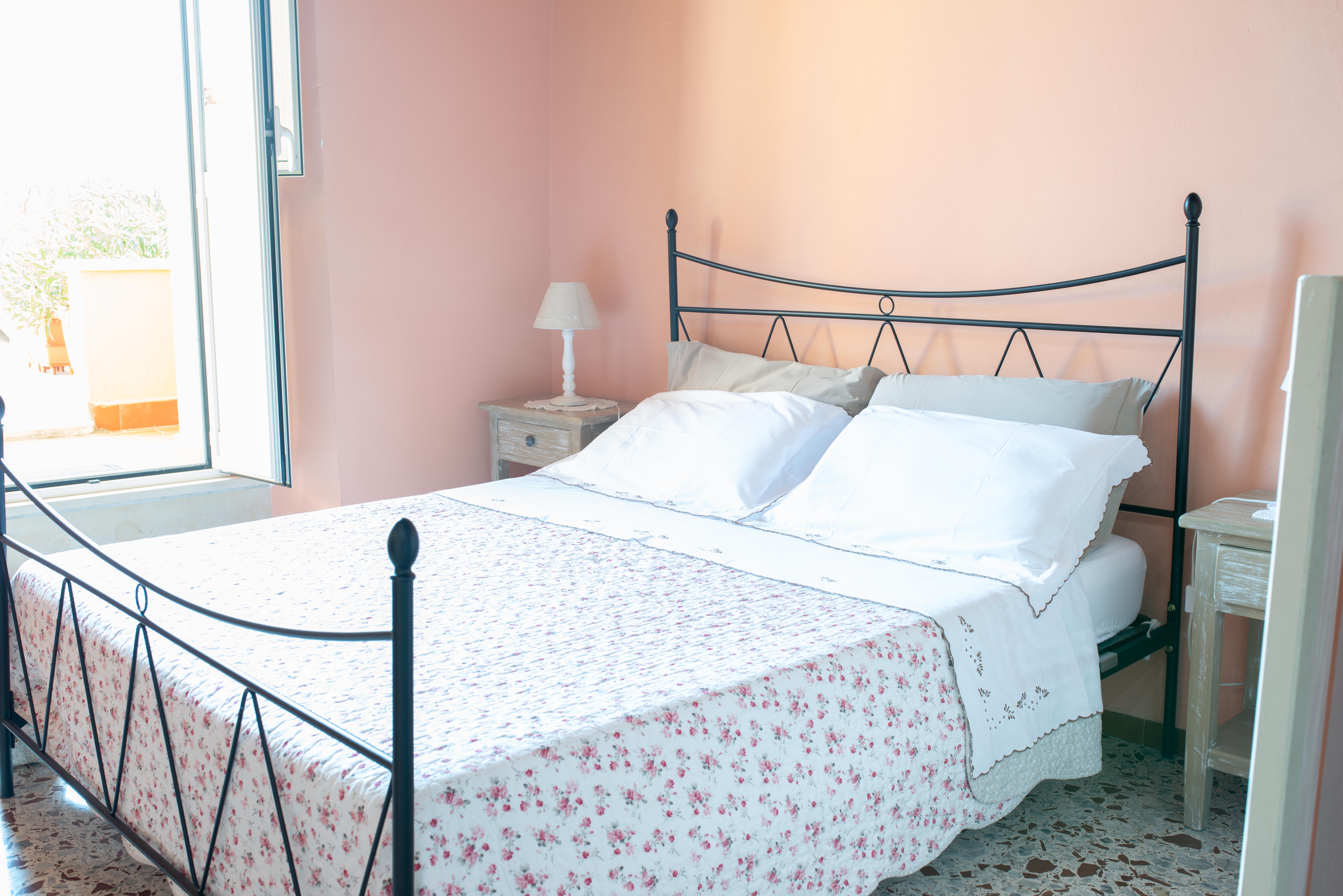 Spaziosa camera in un palazzo di un borgo medievale, dotata di un letto matrimoniale e luce naturale abbondante.