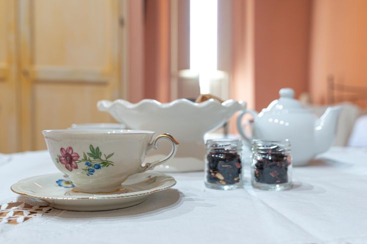 Teeservice mit einer dekorierten Tasse und Dessertbehältern, bereit für eine entspannende Pause.