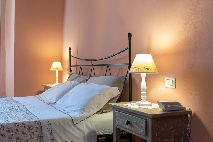 Einfaches Zimmer mit Doppelbetten und sanfter Beleuchtung, ideal für einen ruhigen Aufenthalt.