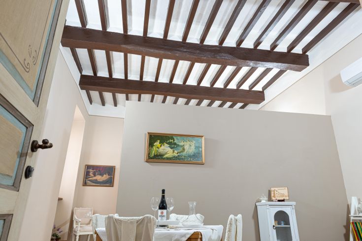 Informeller Raum mit Sichtbalken, einfacher Einrichtung und warmer Atmosphäre, ideal für gemeinsame Mahlzeiten.