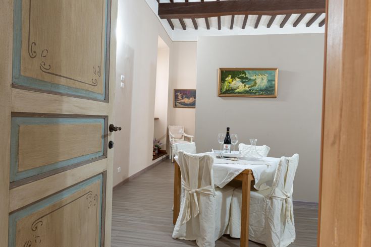 Speisebereich in einer gemütlichen Atmosphäre, mit einem eingedeckten Tisch und einem Weinregal zur Verfügung.