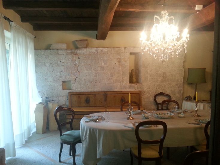 Spacious dining room with a table, chandelier, and stone walls.