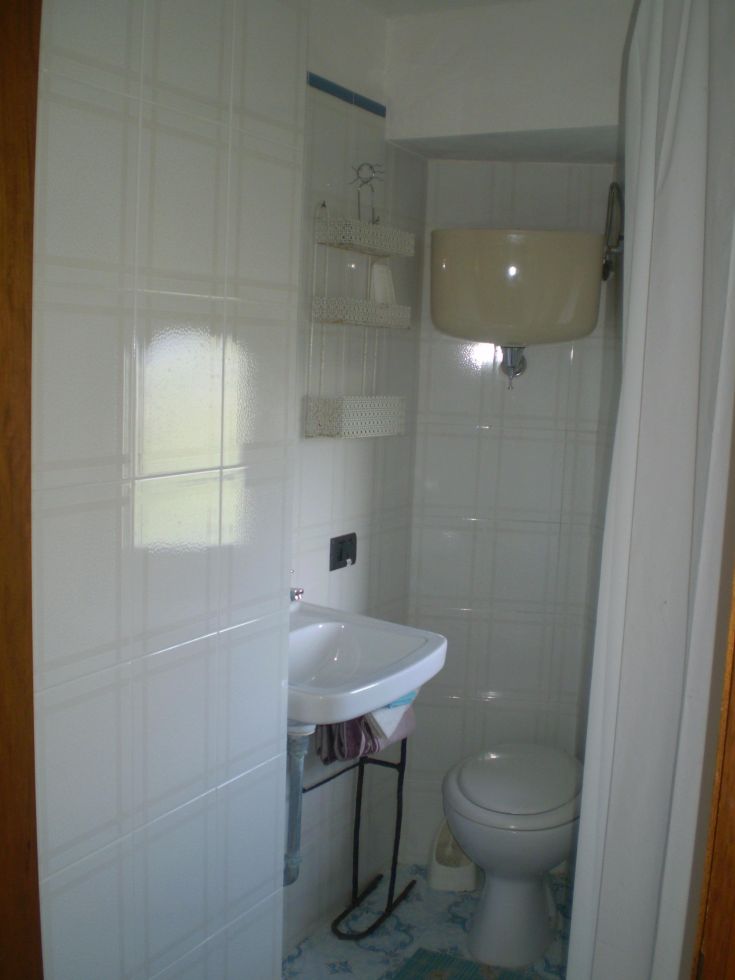 Ein kompaktes Badezimmer mit hellen Fliesen und schlichter Einrichtung.