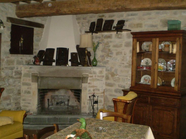 Ein gemütlicher Innenraum mit Kamin, Holzmöbeln und schlichten Dekorationen.