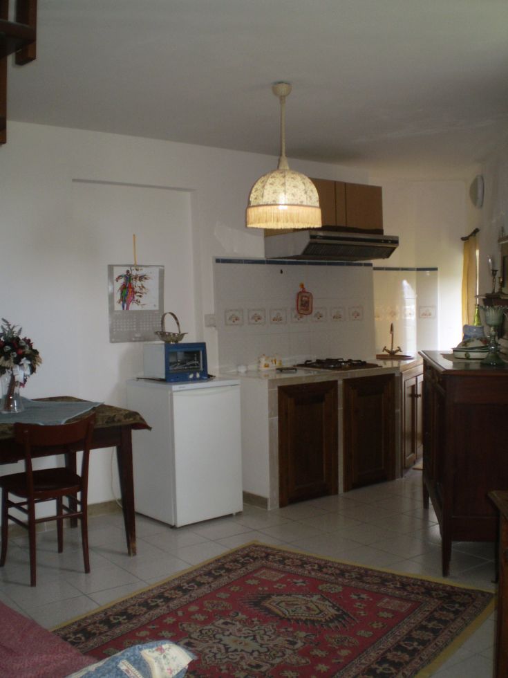 Eine einfache Küche mit einem Tisch und verschiedenen Vorbereitungsutensilien.