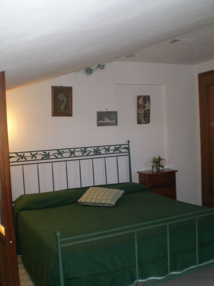 Ein gemütliches Schlafzimmer mit einem Doppelbett, wesentlichen Möbeln und neutralen Farbtönen.