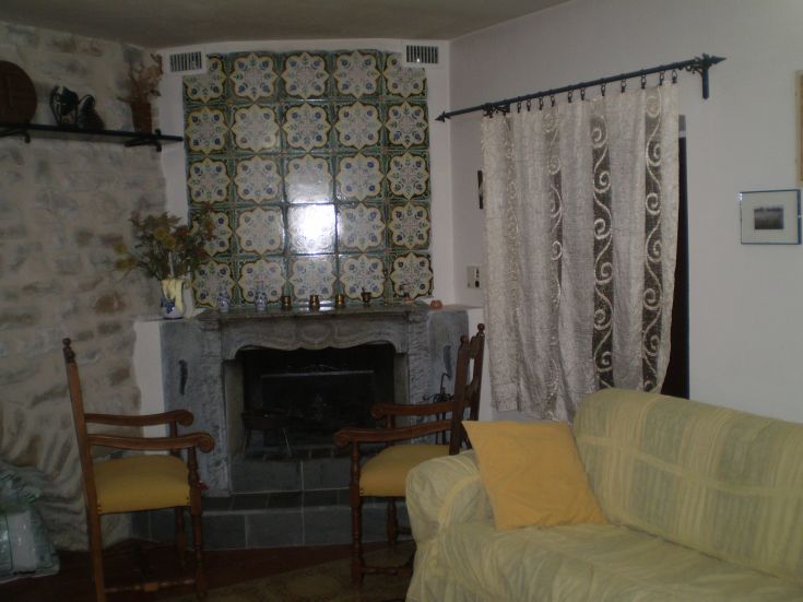 Ein gemütliches Wohnzimmer mit einem Steinkamin und gefliesten Wänden.