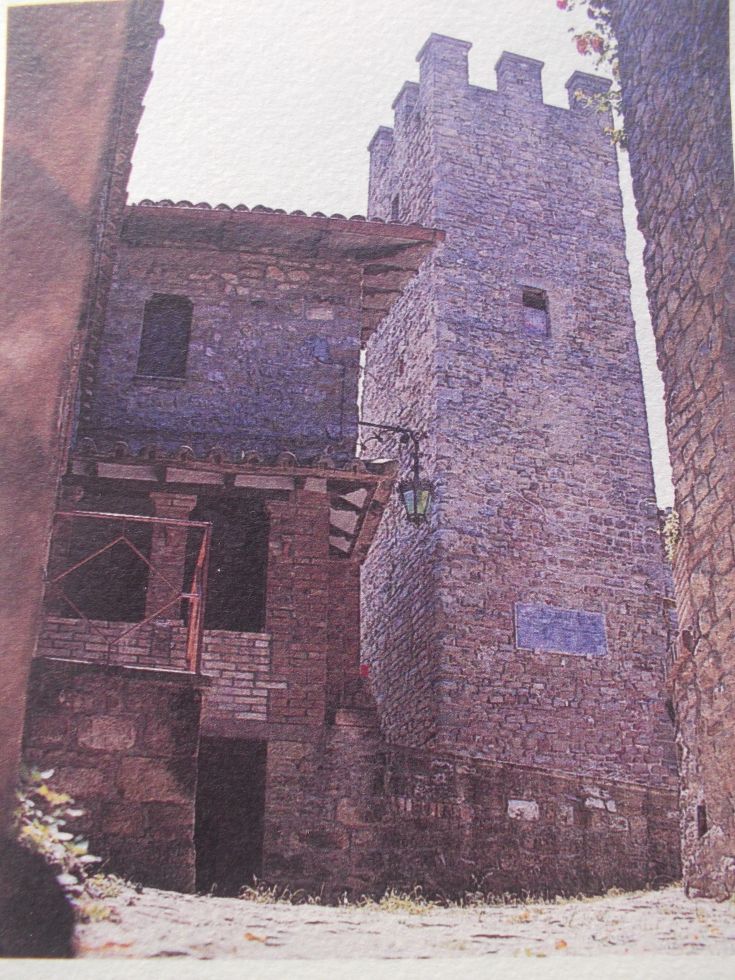 Eine charmante Ecke mit Steingebäuden und einem historischen Turm in einem alten Dorf.