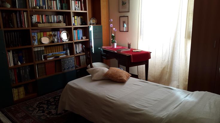 Chambre confortable avec une bibliothèque, un berceau et un bureau. Un environnement serein et lumineux.