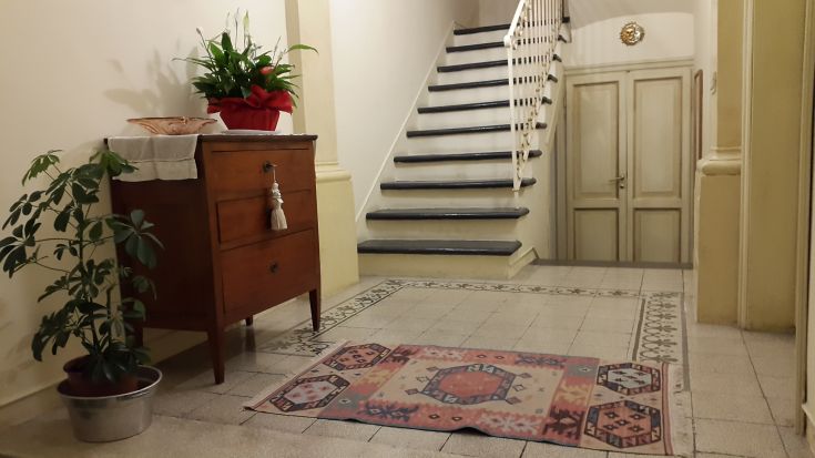 Un hall accueillant avec un escalier et un mobilier classique, idéal pour des moments de détente.
