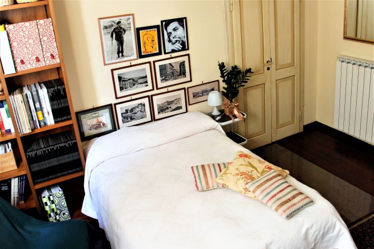 Chambre lumineuse avec des meubles fonctionnels et quelques décorations murales. Un espace confortable et soigné.