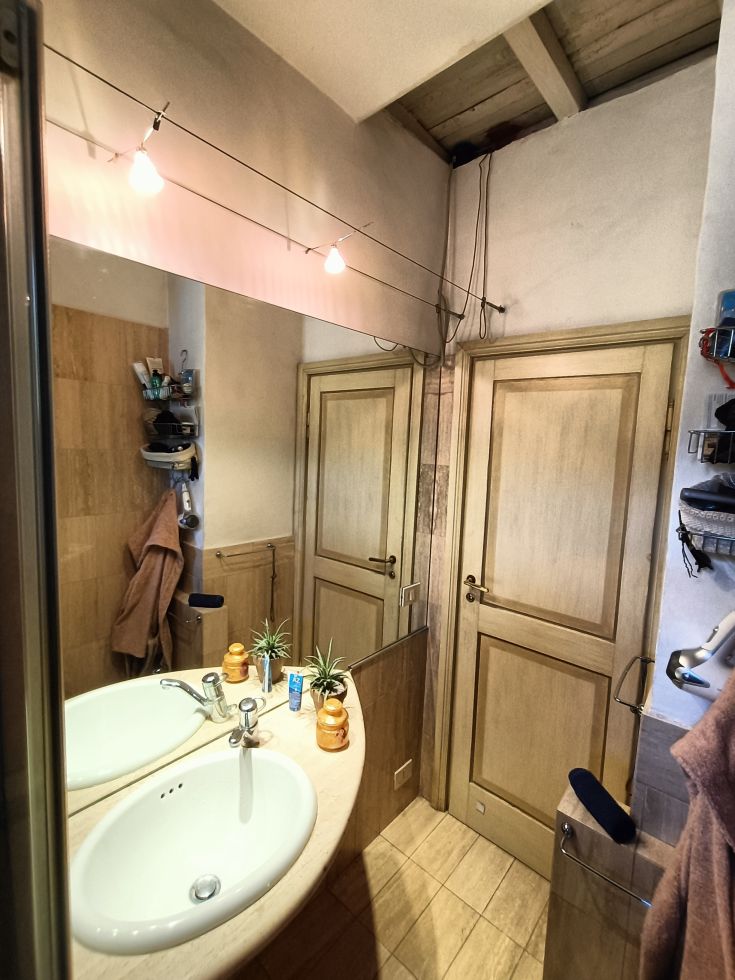 Une salle de bain moderne avec un double lavabo, un souci du détail et bien éclairée par des lampes suspendues.