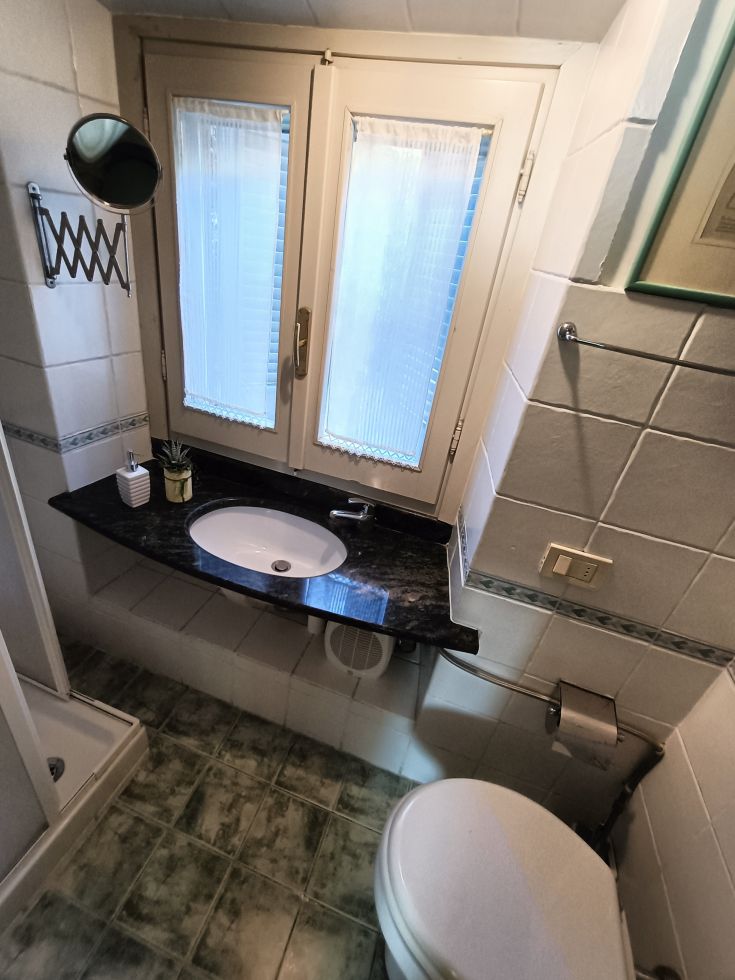 Salle de bain fonctionnelle avec fenêtre, lavabo et douche, pratique pour tous les usages.