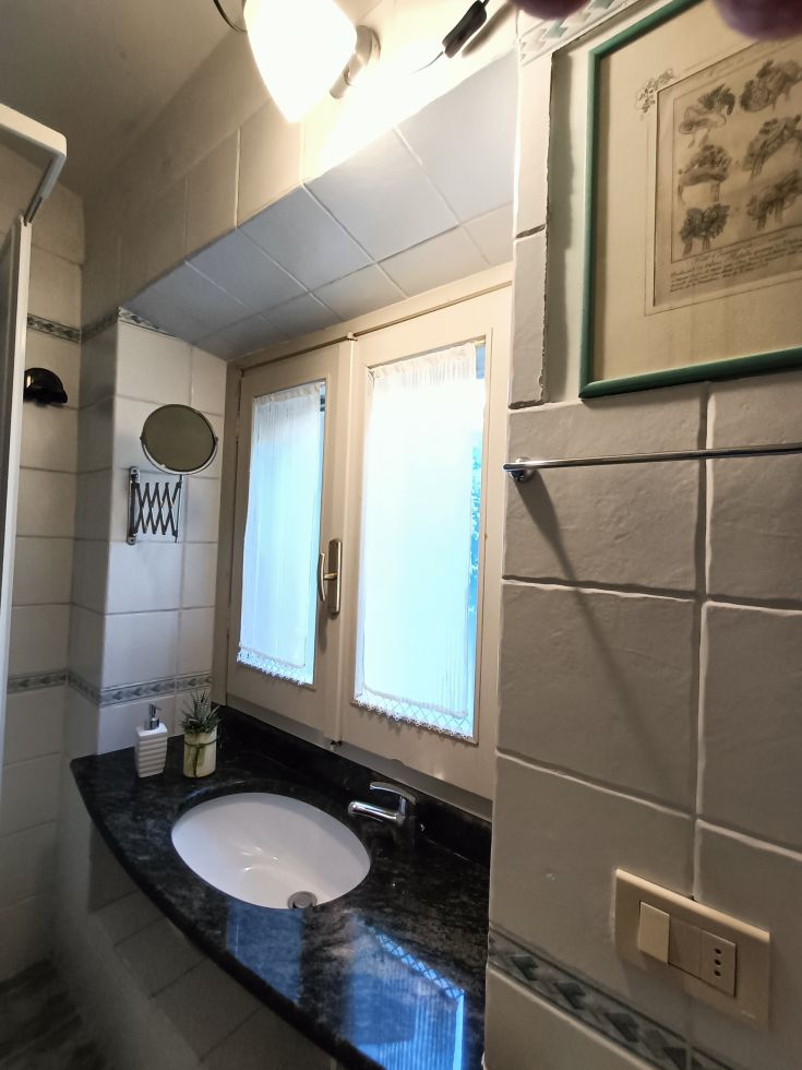 Salle de bain moderne lumineuse avec un lavabo contemporain et une fenêtre, conçue pour le confort et la praticité.