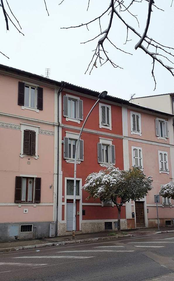 Un bâtiment coloré entouré d'arbres couverts de neige, situé dans une rue tranquille.