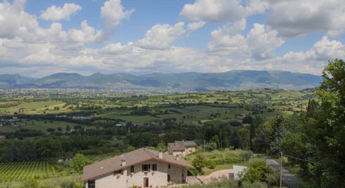 Scena di colline verdi e case in pietra, perfetta per un ambiente rilassato.